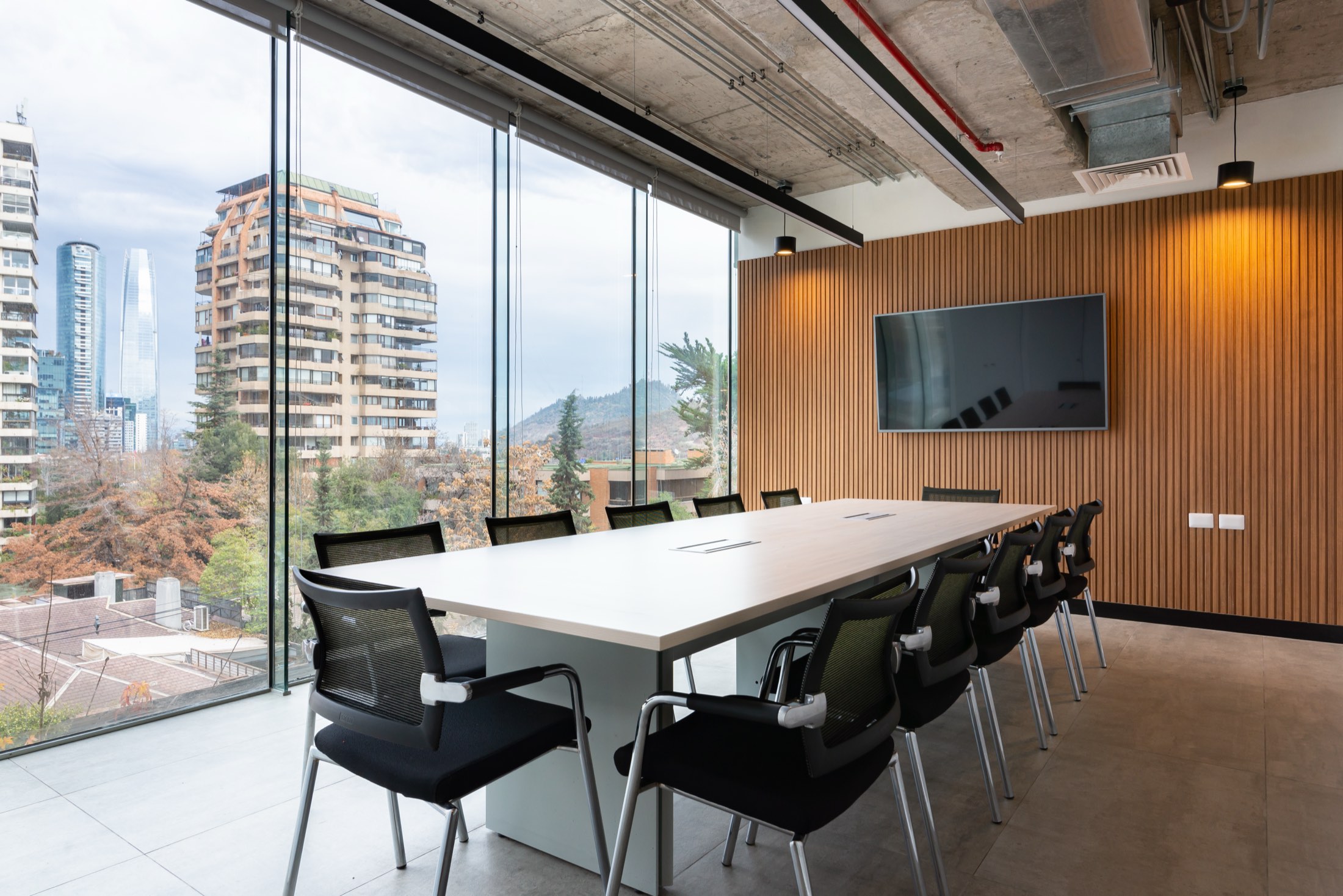 Sala de directorio de SIV Abogados con ventanal de piso a techo y vista a Santiago