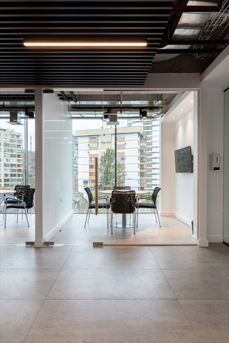 Sala de reuniones vidriada con vista a los edificios del sector
